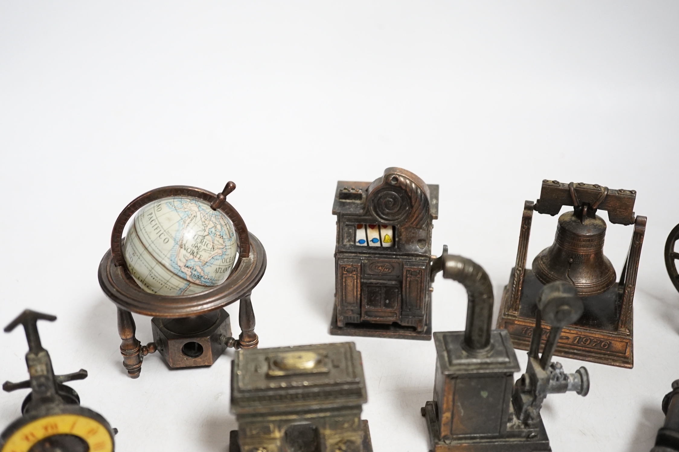 A collection of novelty metal pencil sharpeners and a pair of late Georgian silver plated candlesticks, 20cm